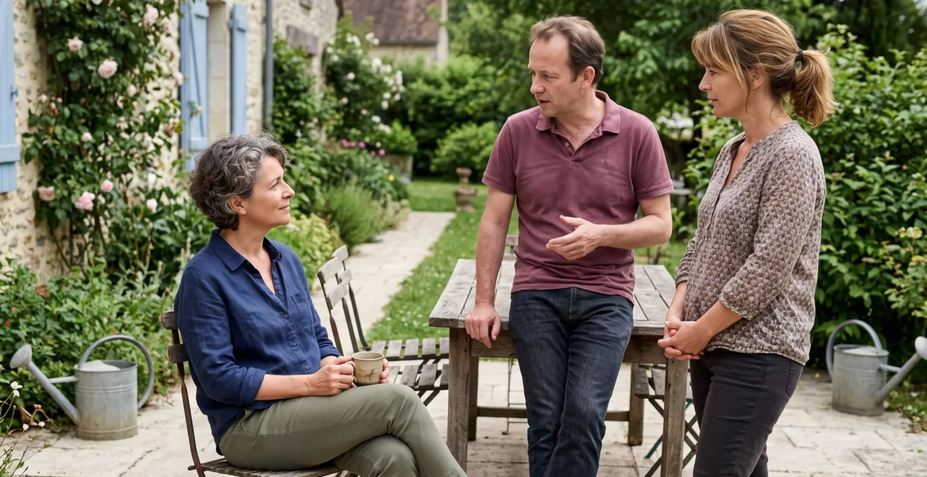 Trois adultes d'une même fratrie en discussion informelle sur la terrasse d'une maison familiale française